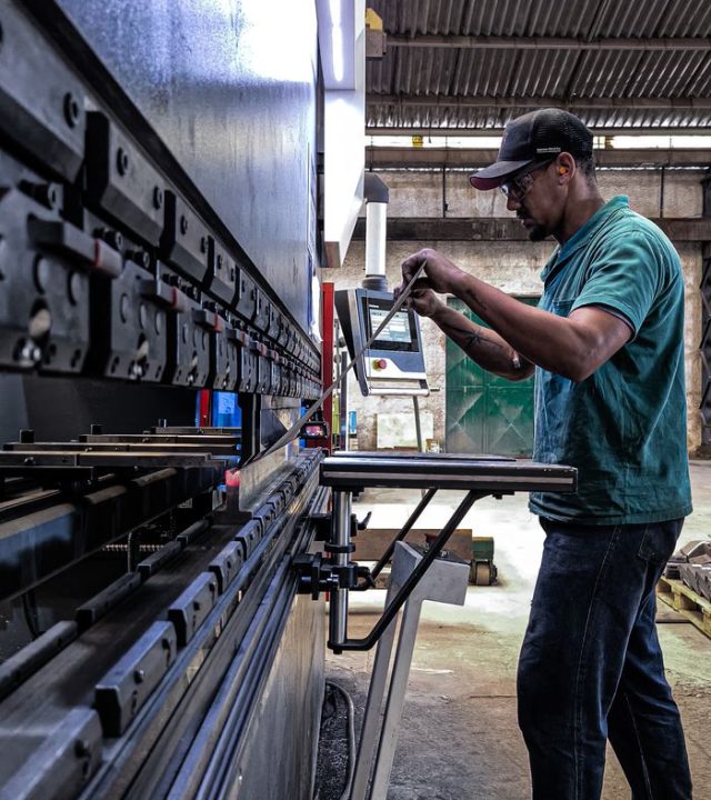 Engineer using machinery in a factory setting, focusing on precision and skill.